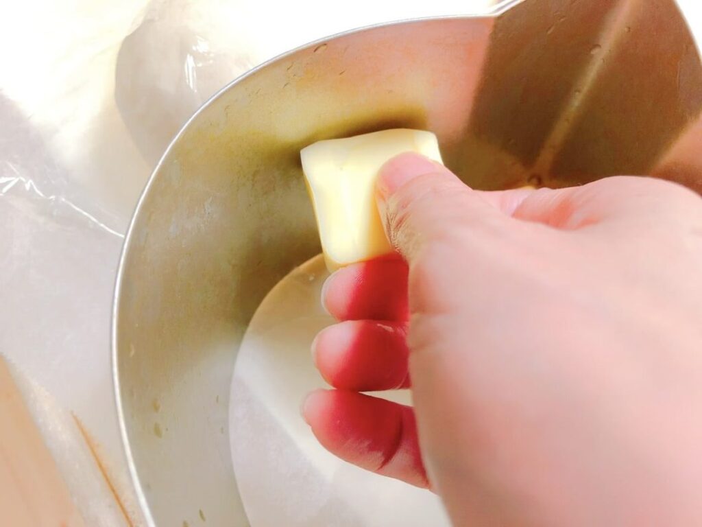 パン型にバターを塗っている写真