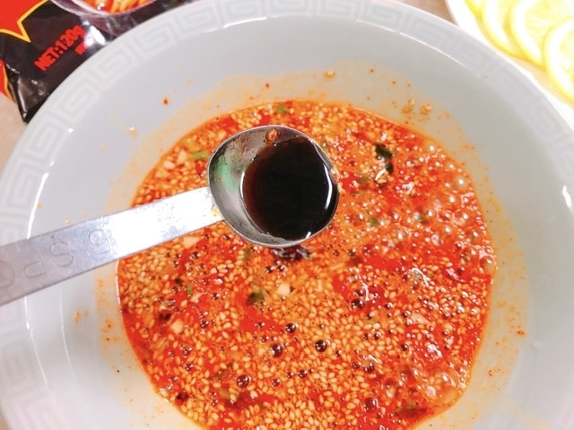 雪碧拌面のスープに醤油と香醋を入れている写真