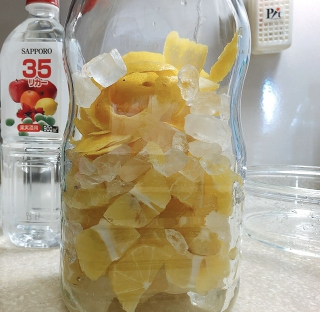 広口瓶に、レモン果実と氷砂糖を入れた写真