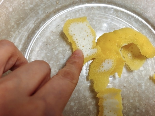 レモンの皮の白い部分を指さしている写真